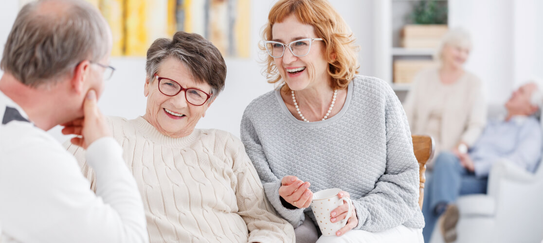 Three elderly people speaking
