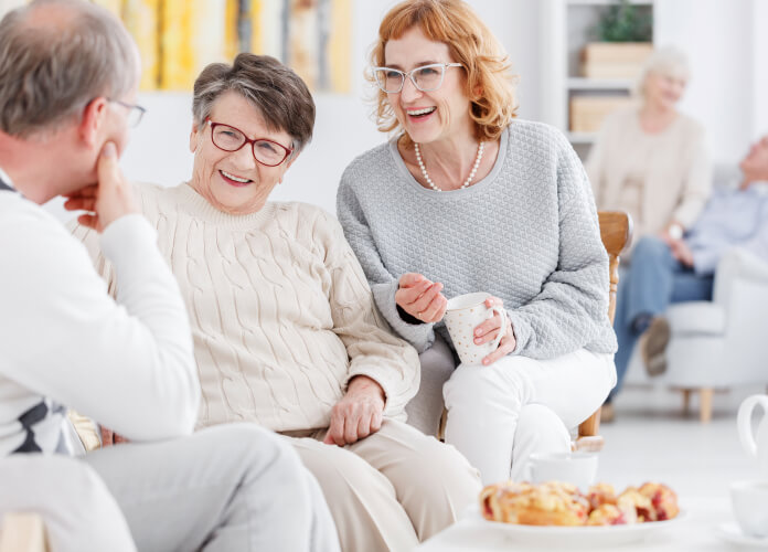 Three elderly people speaking
